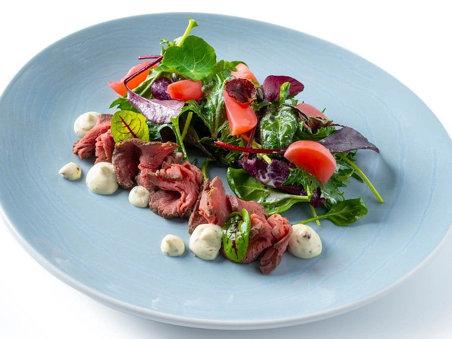 Green leaves salad with roasted beef tenderloin scented with truffles
